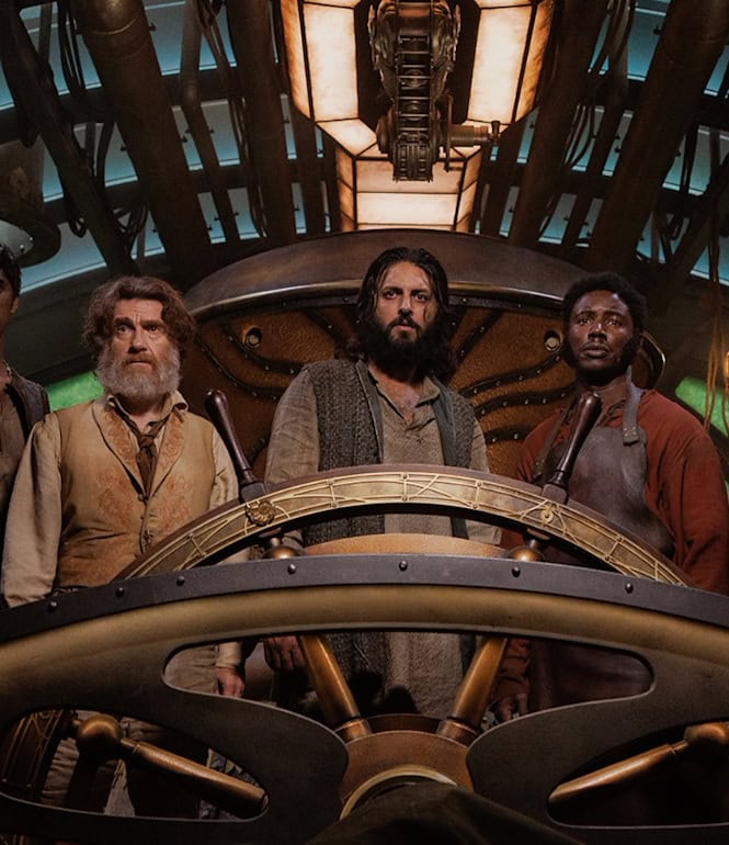 Gruppenfoto der Hauptdarsteller:innen der Abenteuer-Serie 'Nautilus' an Bord eines historischen U-Boots mit Steuerrad und technischer Ausstattung im Hintergrund.