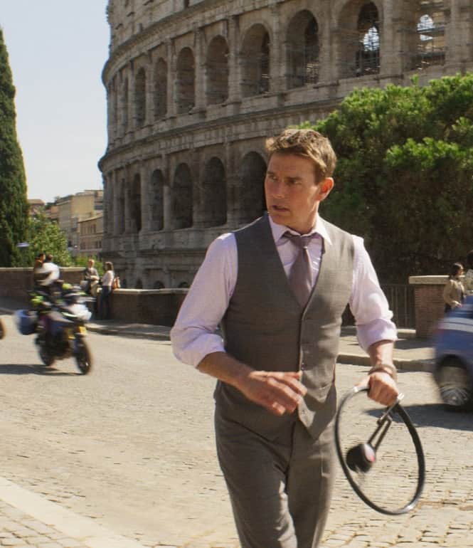 Tom Cruise als Ethan Hunt in einer Action-Szene vor dem Kolosseum in Rom, mit Motorrädern und Autos im Hintergrund – Szene aus ‚Mission: Impossible – Dead Reckoning, Teil Eins‘