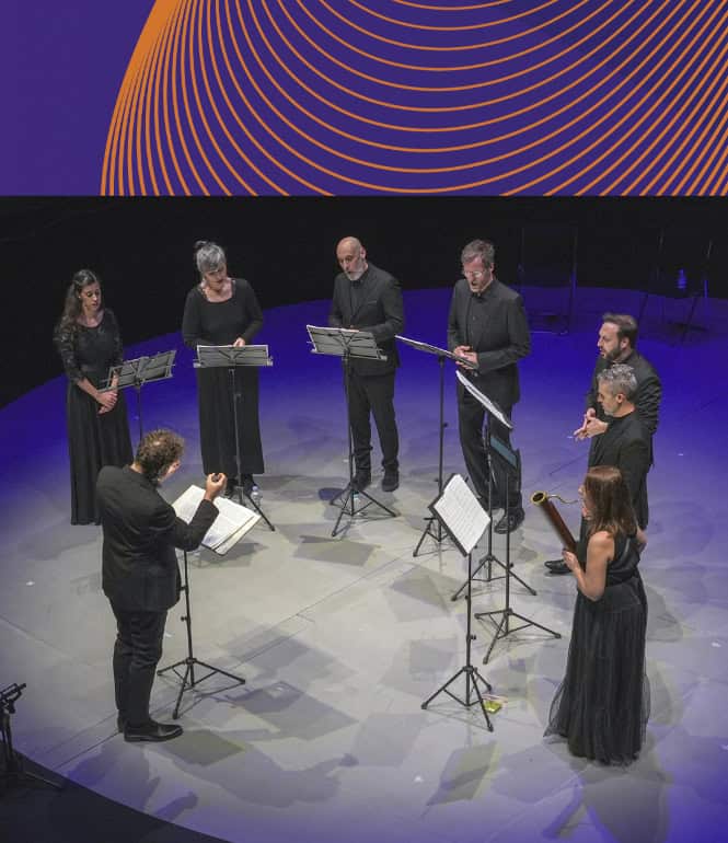 A-cappella Leipzig: Vokalensemble singt auf Bühne mit Dirigent und Notenständern