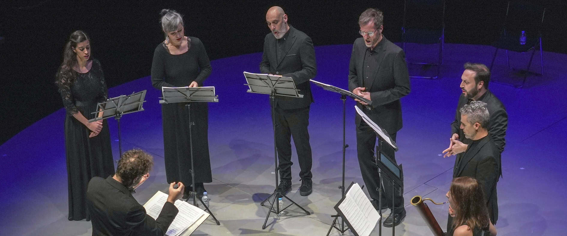 A-cappella Leipzig: Vokalensemble singt auf Bühne mit Dirigent und Notenständern