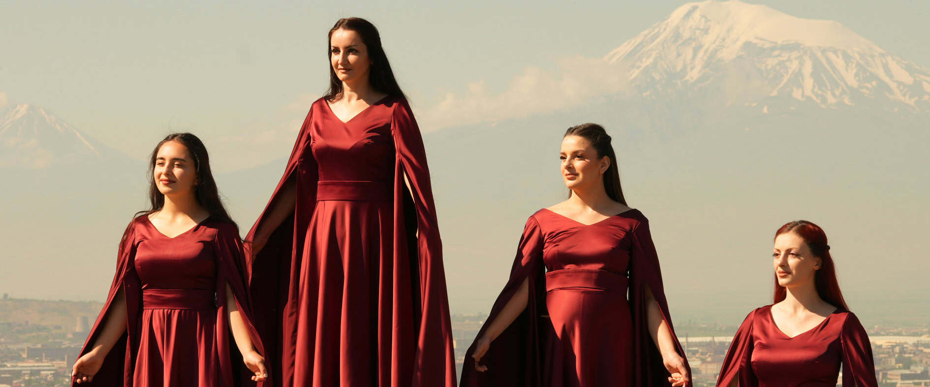 Nairyan Vocal Ensemble in roten Konzertkleidern vor Bergkulisse beim Festival a cappella in Leipzig