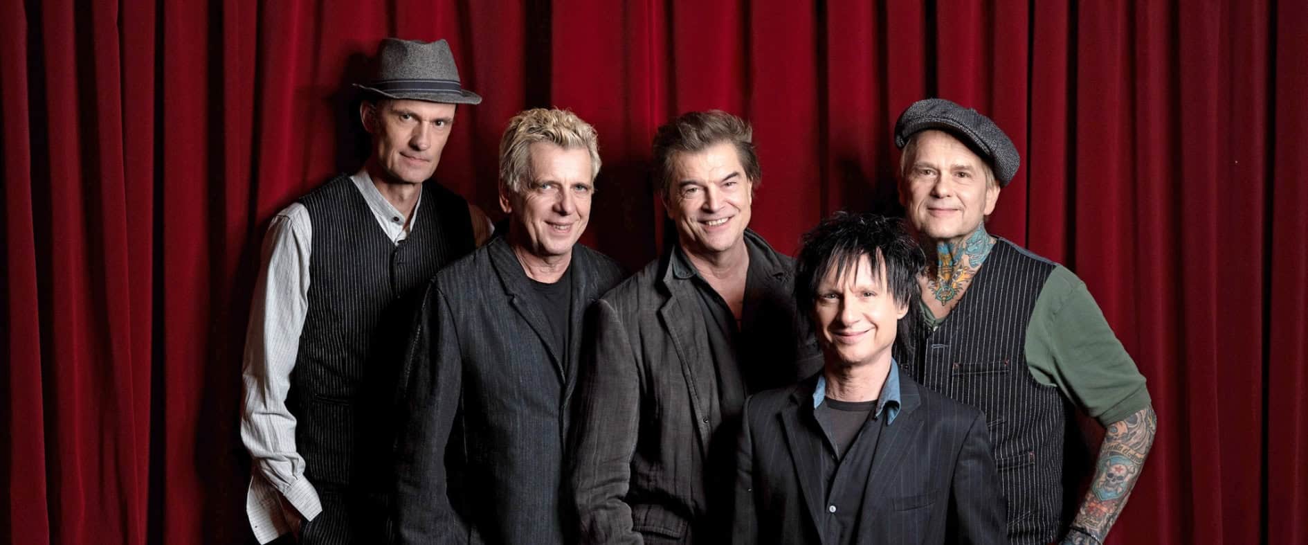 Die Toten Hosen vor rotem Vorhang – Bandfoto der fünf Mitglieder