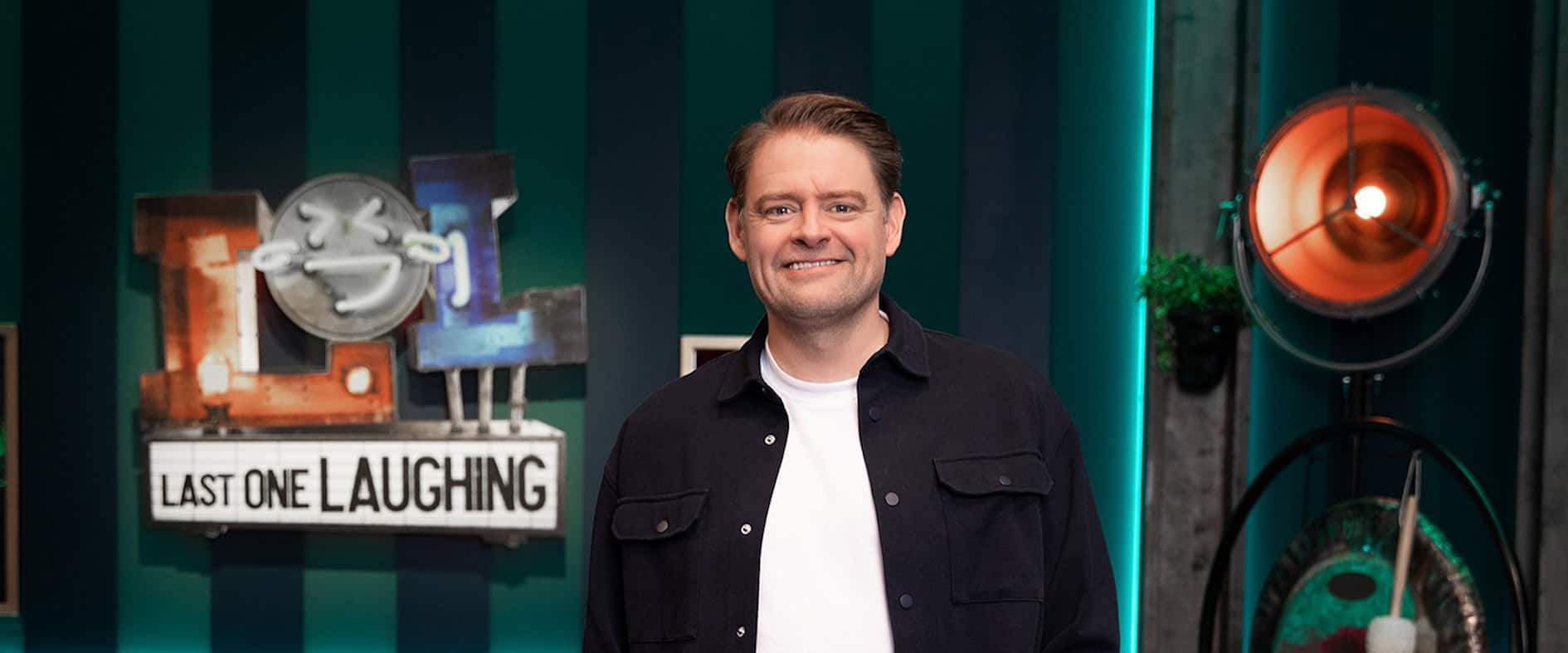 Max Giermann steht lächelnd auf der Bühne von „Last One Laughing“