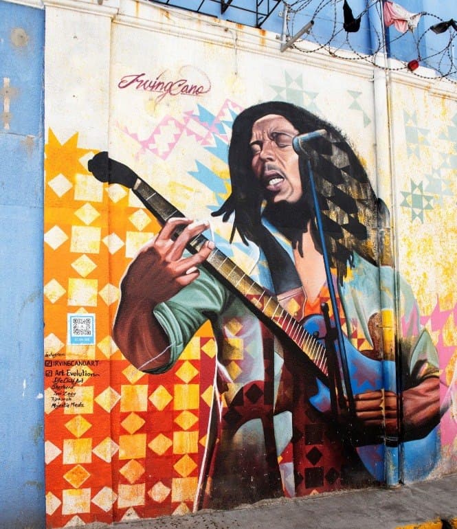 Graffiti von Bob Marley mit Gitarre und Mikrofon an einer Wand
