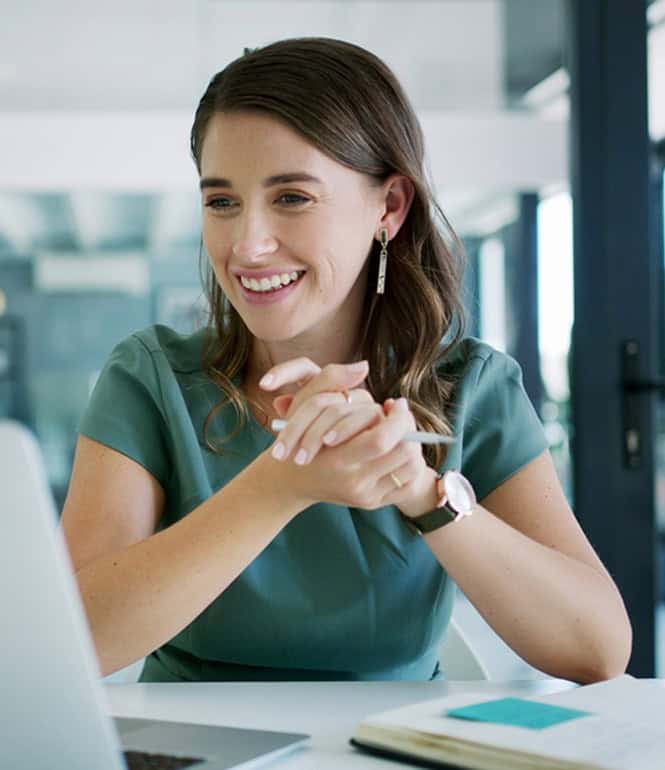Lächelnde Frau am Laptop – Symbol für pragmatischen Optimismus und mentale Balance im Alltag.