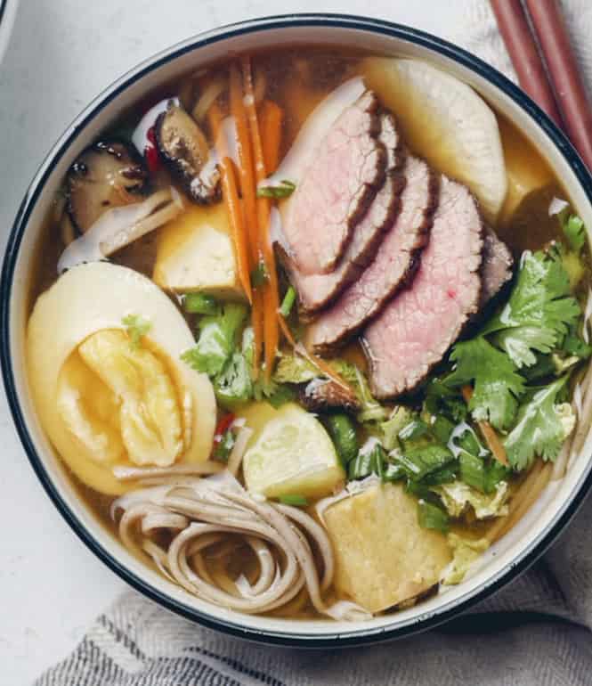 Miso-Ramen-Suppe mit gebratenem Rindfleisch, Ramennudeln, Shiitake-Pilzen, Möhren, Rettich, Tofu, Chinakohl und Ei in einer Schüssel