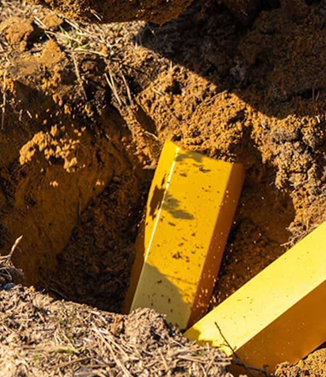 Spaten und Goldbarren in ausgehobener Erde