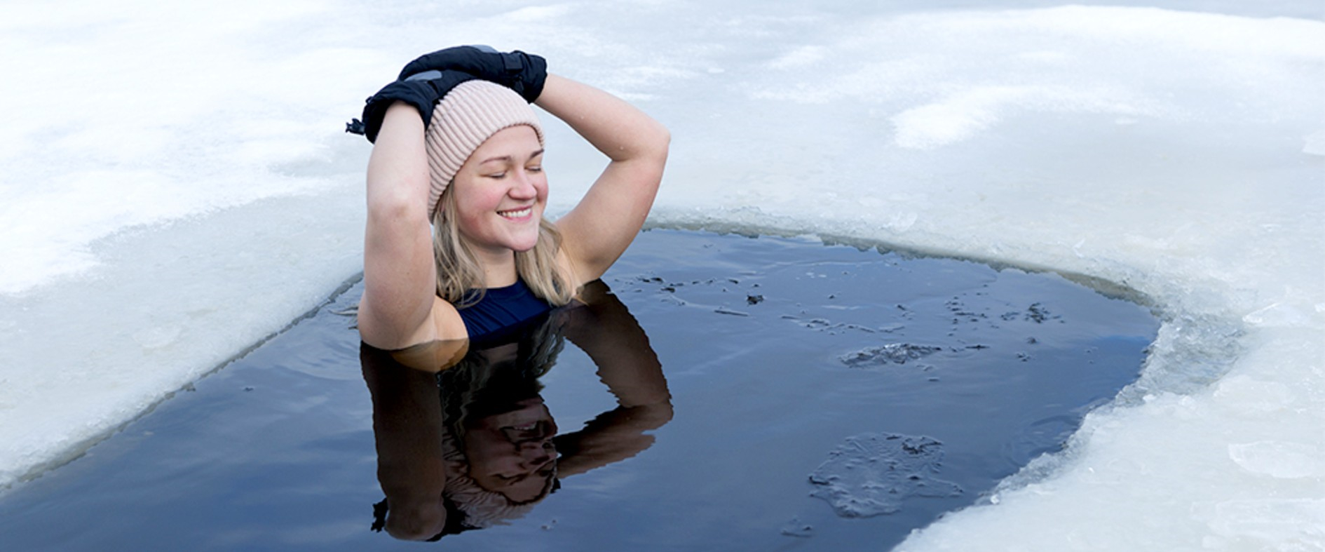 Frau im Neoprenanzug und Mütze im eiskalten Wasser