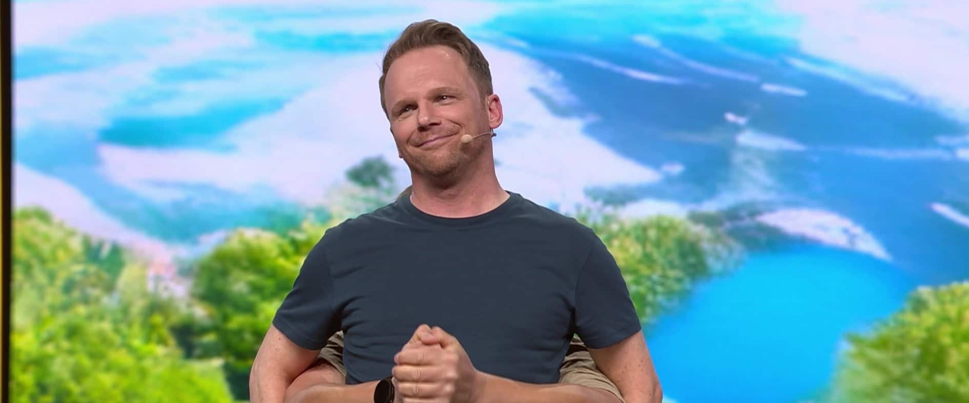 Comedian Ralf Schmitz mit Headset vor LED-Wand mit Landschaft
