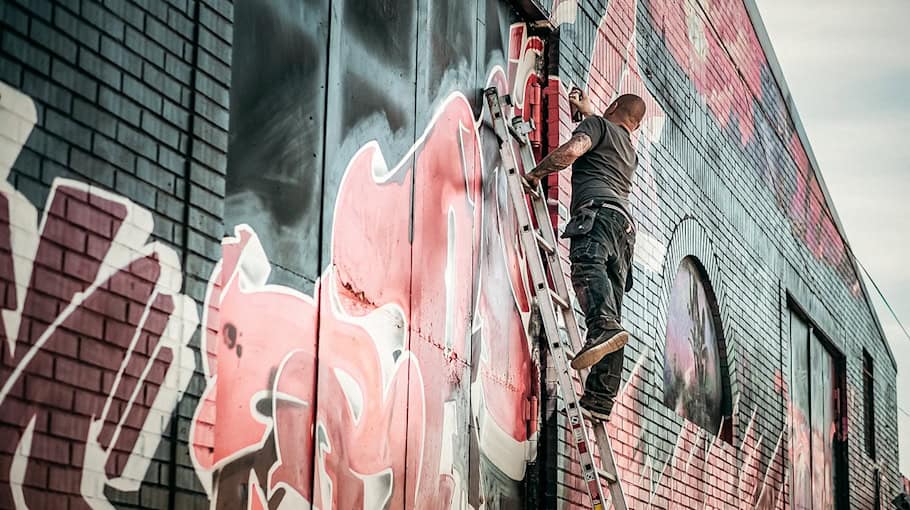 Unbekannte besprühen Gebäude mit violetter Farbe