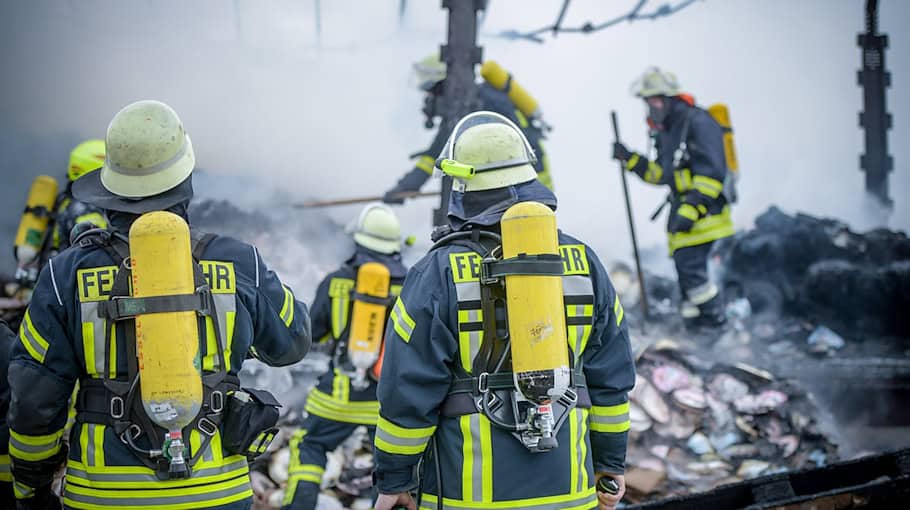 Einsatzkräfte Löschen Brand in Mehrfamilienhaus