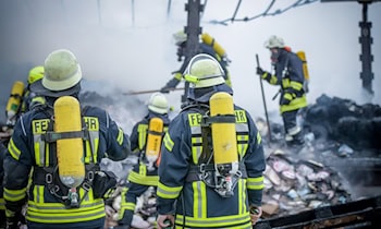 Einsatzkräfte Löschen Brand in Mehrfamilienhaus
