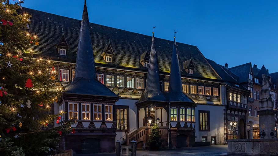 Mann sägt Weihnachtsbaum am Obermarkt an